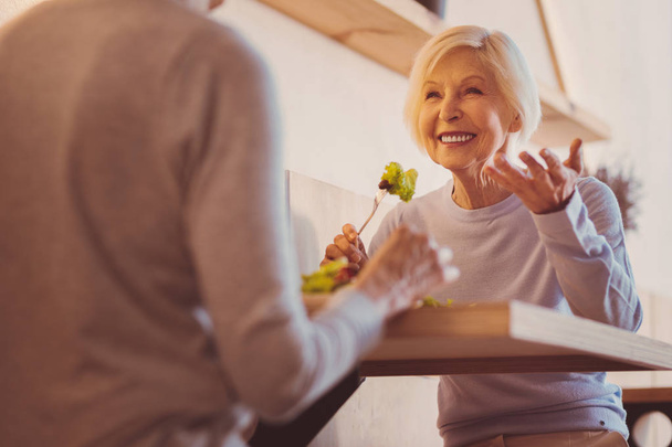 Щаслива старша жінка ділиться історіями зі своїм другом в кафе
 - Фото, зображення