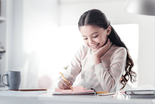 Pleased brunette girl making notes - Fotografie, Obrázek
