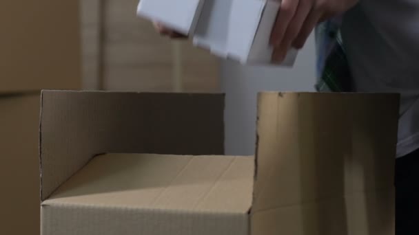 Man packing stuff into carton, divorce, division of property, moving from house - Video