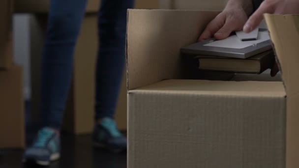 Angry wife waiting until husband gathering stuff into cardboard box, divorce - Séquence, vidéo