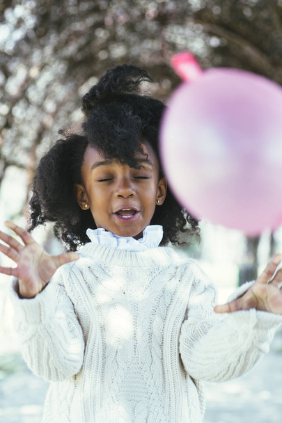Girl blowing balloon outside - Fotoğraf, Görsel