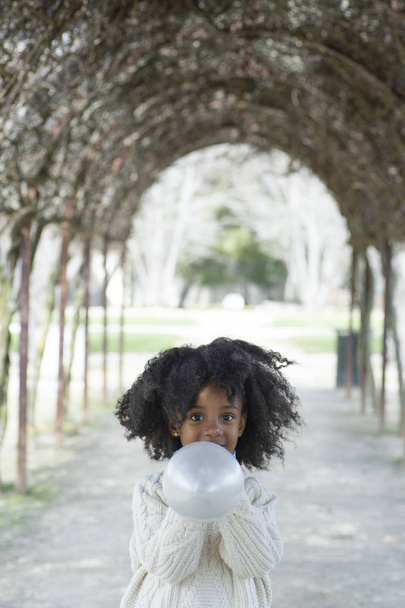 Menina soprando balão fora
 - Foto, Imagem