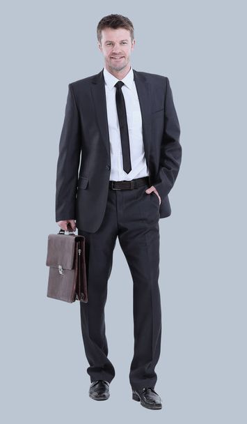 Handsome young business man standing on gray background - Fotoğraf, Görsel