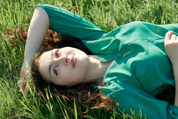 beautiful girl lying on the grass at sunny day, face closeup, summer forest, bright landscape with shadows - Φωτογραφία, εικόνα