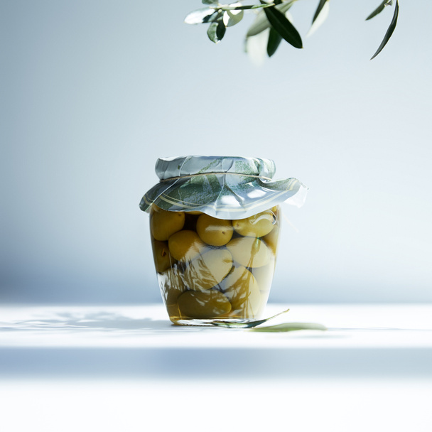 pot d'huile aromatique aux olives vertes et branche sur fond blanc
 - Photo, image