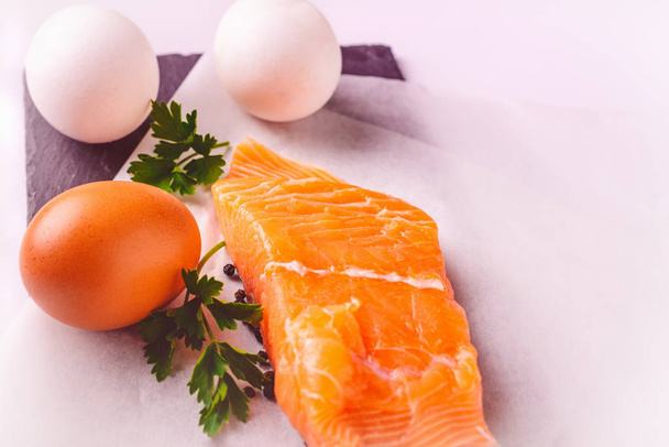 Egészséges élelmiszer, fehérjék, főzés és diéta fogalma - zár-megjelöl-a lazac filé, a tojás és a petrezselyem, a fehér háttér. - Fotó, kép