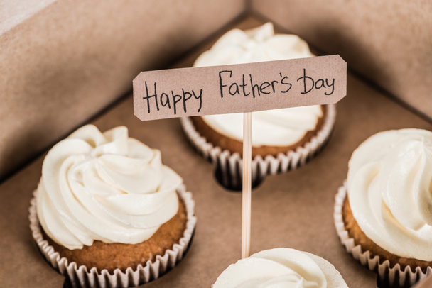 Close-up shot van de smakelijke cupcakes in doos met Happy vaders dag inscriptie - Foto, afbeelding