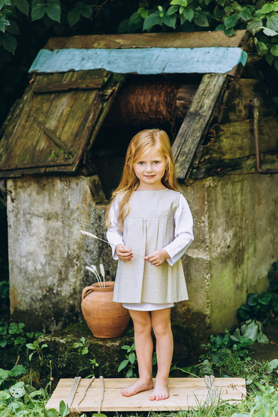 cute little girl with blond hair outdoors - Foto, afbeelding
