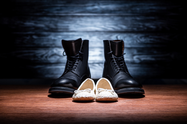 Close-up shot van vader en dochter schoenen op houten ondergrond, Happy vaders dag concept - Foto, afbeelding