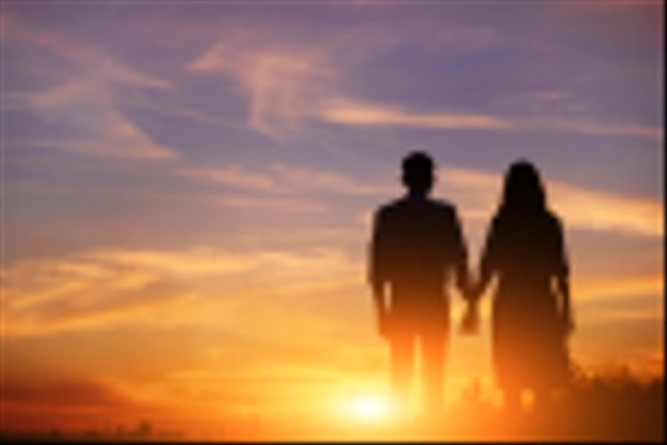若いカップルが手を繋いでいる日没のシルエットをバックに. - 写真・画像