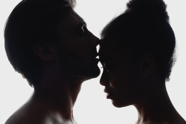 vue latérale des silhouettes de couple interracial amoureux
 - Photo, image