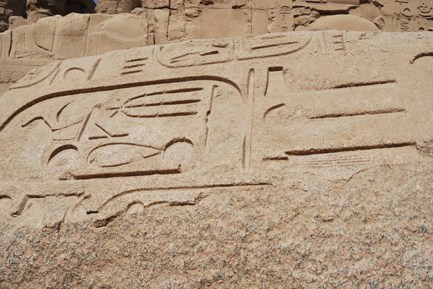 Egyptische hiërogliefen macro close-up shot tijdens een toeristische reis in heel Afrika. Bezuinigen op een granieten stella in de tempel van Karnak. - Foto, afbeelding
