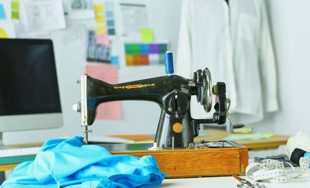Máquina de coser retro en el escritorio de ropa de diseñador
 - Foto, Imagen