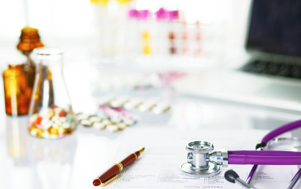 bir doktor ofisi ile bir stetoskop ön planda ve arka planda, seçici odak hapları bir şişeyle Resepsiyon closeup - Fotoğraf, Görsel