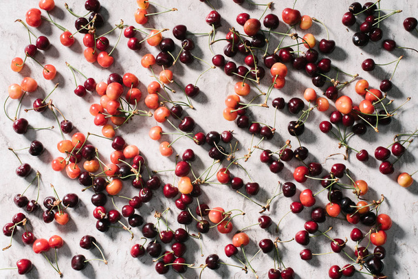 top view of fresh ripe organic healthy cherries on marble background  - 写真・画像
