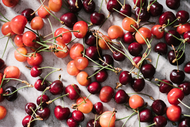 top view of fresh ripe organic cherries on marble surface  - Photo, Image