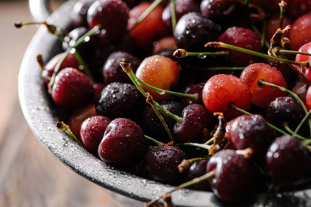 close-up view of fresh sweet organic cherries with water drops in colander - Foto, immagini