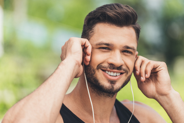 portrait of young man listening music with earphones  - Photo, Image