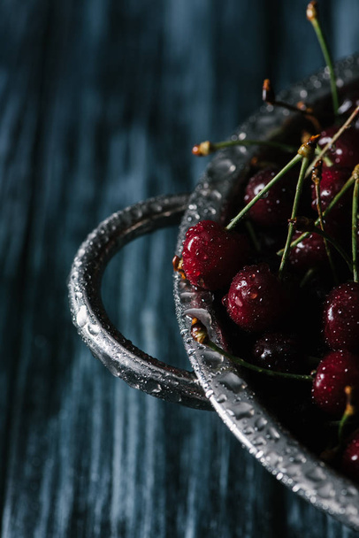 close-up view of fresh ripe sweet cherries in wet metallic pan - Photo, Image