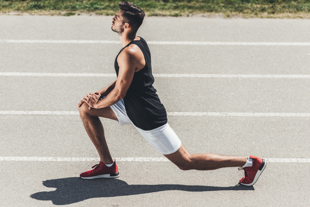 boční pohled na mužské běžec na Běžecká stopa na sportovní hřiště  - Fotografie, Obrázek