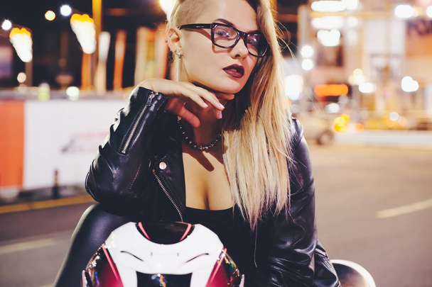 Retrato mulher motociclista desfrutando noite cidade vida e luzes sentado
 - Foto, Imagem