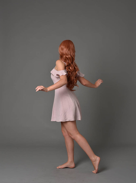 full length portrait of girl wearing  pink summer dress. standing pose on grey studio background - Foto, immagini