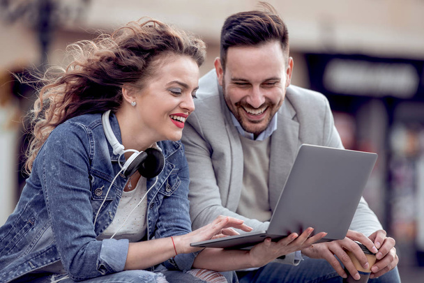 Portrait de couple amoureux relaxant et regardant l'ordinateur portable à l'extérieur, s'amuser
. - Photo, image