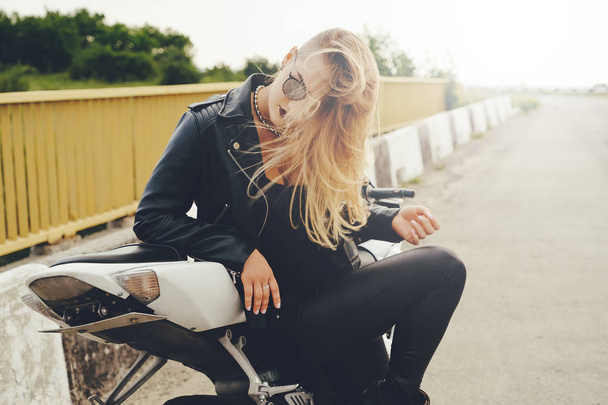 美しい女性がバイクにサングラスでポーズ - 写真・画像
