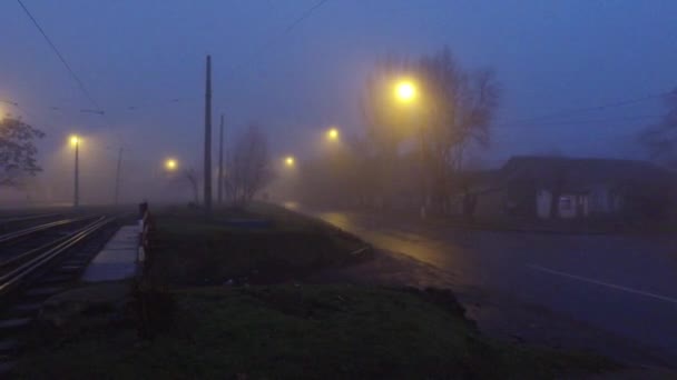 トラムのレールと枕木の夜市では濃い霧の中。市の郊外に濃い霧と夜の街 - 映像、動画