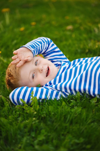 little boy lying on the grass - 写真・画像