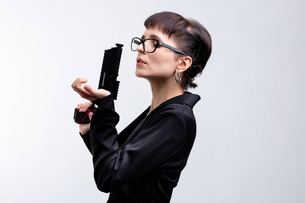 Çekici bir kapak kadın ajan kopya alanı ile beyaz bir arka plan üzerinde tabanca ile altında bir portresi. - Fotoğraf, Görsel