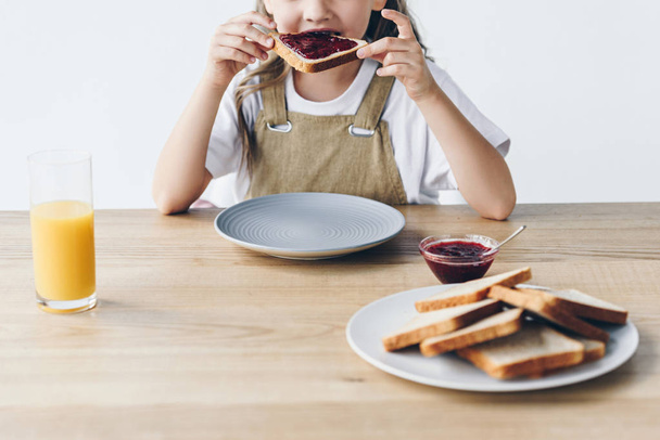 przycięte zdjęcie małe dziecko jedzenie tostów z dżemem na białym tle - Zdjęcie, obraz