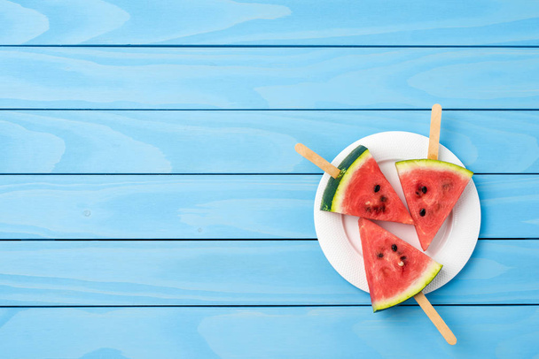 Watermeloen slices op blauwe houten tafel. Voedsel achtergrond - Foto, afbeelding