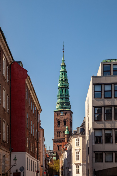 old tower with tall spire and historical buildings on street in copenhagen, denmark - Fotoğraf, Görsel