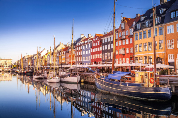 COPENHAGEN, DENMARK - MAY 6, 2018: picturesque view of historical buildings and moored boats reflected in calm water, copenhagen, denmark - Фото, изображение