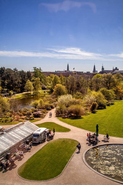 COPENHAGEN, DENMARK - MAY 6, 2018: aerial view of trees and pond in park and people sitting at tables in Copenhagen, Denmark - Φωτογραφία, εικόνα