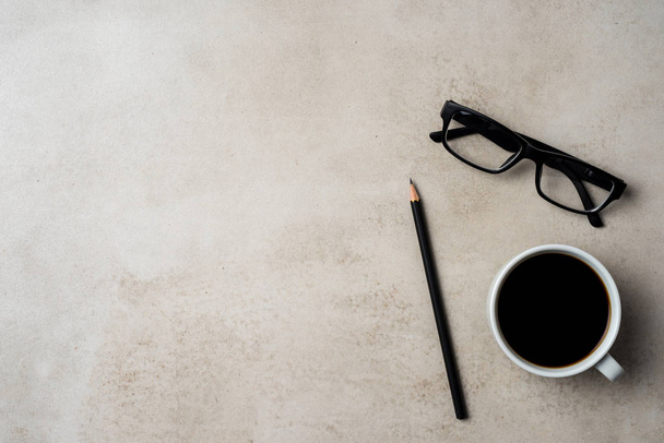 Office desktop with coffee cup, pencil and glasses - Foto, Imagem