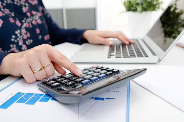 Accountant counts tax, works with laptop. Tax, accounting finance female business concept - Foto, Imagem