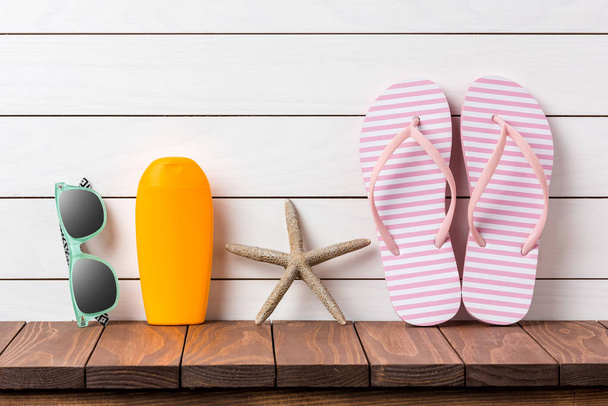Flip flops with beach accessories on wooden background - Photo, image