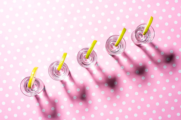 Glasses of vodka on pink dotted background - Photo, image