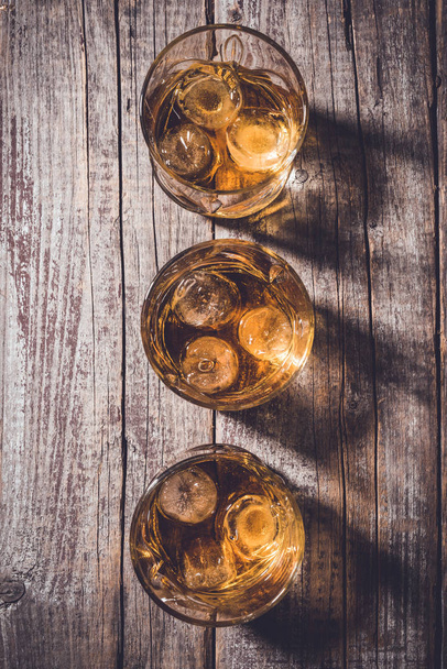 Whiskey glasses on an old wooden table. Close up - Foto, Imagen