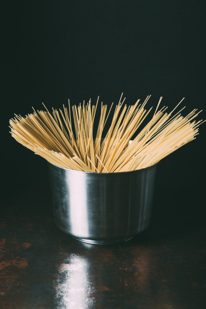 vista de cerca de espaguetis crudos en sartén sobre fondo negro
  - Foto, Imagen
