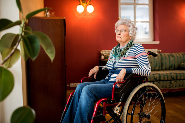 Loneliness senior woman sitting in wheelchair at nursing home, forgotten by the family - Photo, Image