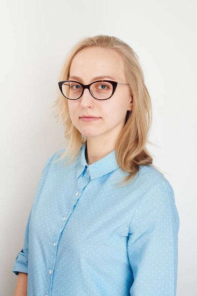 businesswoman wearing blue shirt and glasses looking at camera isolated on white background - Valokuva, kuva