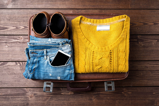 Female warm clothing for winter or autumn on top of vintage suitcase. Close up - Foto, Imagen