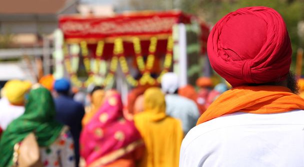 sikh Mann mit rotem Turban mit vielen Menschen während einer religiösen Zeremonie - Foto, Bild