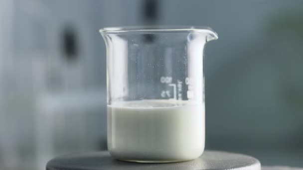 実験。テストの牛乳します。試薬と混合反応ガラスのミルク - 映像、動画