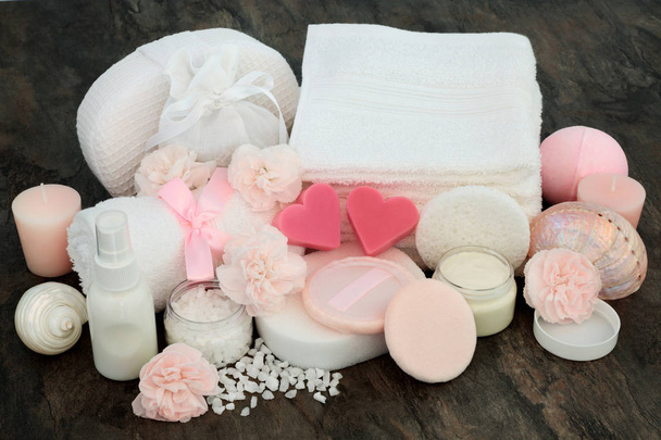 Spa προϊόντα θεραπείας ομορφιάς συμπεριλαμβανομένων ροζ ενυδατική κρέμα, πρώην foliating αλάτι, σε σχήμα καρδιάς σαπούνι, λουλούδια, σφουγγάρια, παντεσπάνι, λοσιόν σώματος και διακοσμητικά κοχύλια σε μαρμάρινο φόντο. - Φωτογραφία, εικόνα