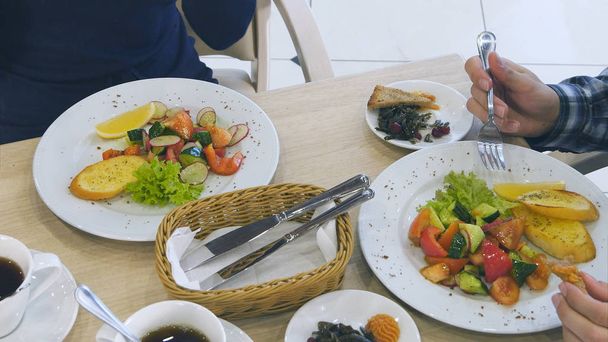 Healthy vegetable salads young family eating at restaurant. - Valokuva, kuva