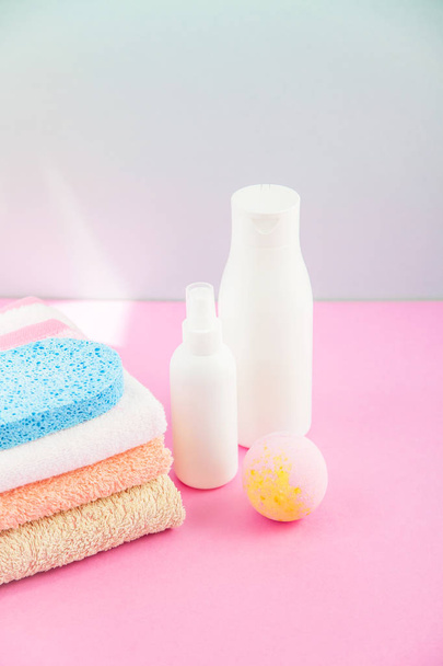 bathroom accessories - towels and shampoos,bath foam, cream on a light, bright blue and pink background The concept of caring for yourself, your body. copy space - Φωτογραφία, εικόνα
